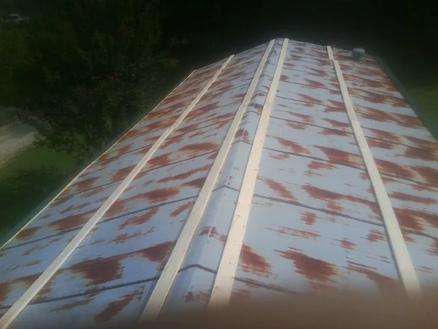 Rusted metal roof panels with new wood purlins before replacement — Storm Damage Roof Repair in Haydenville by Roofing Brothers