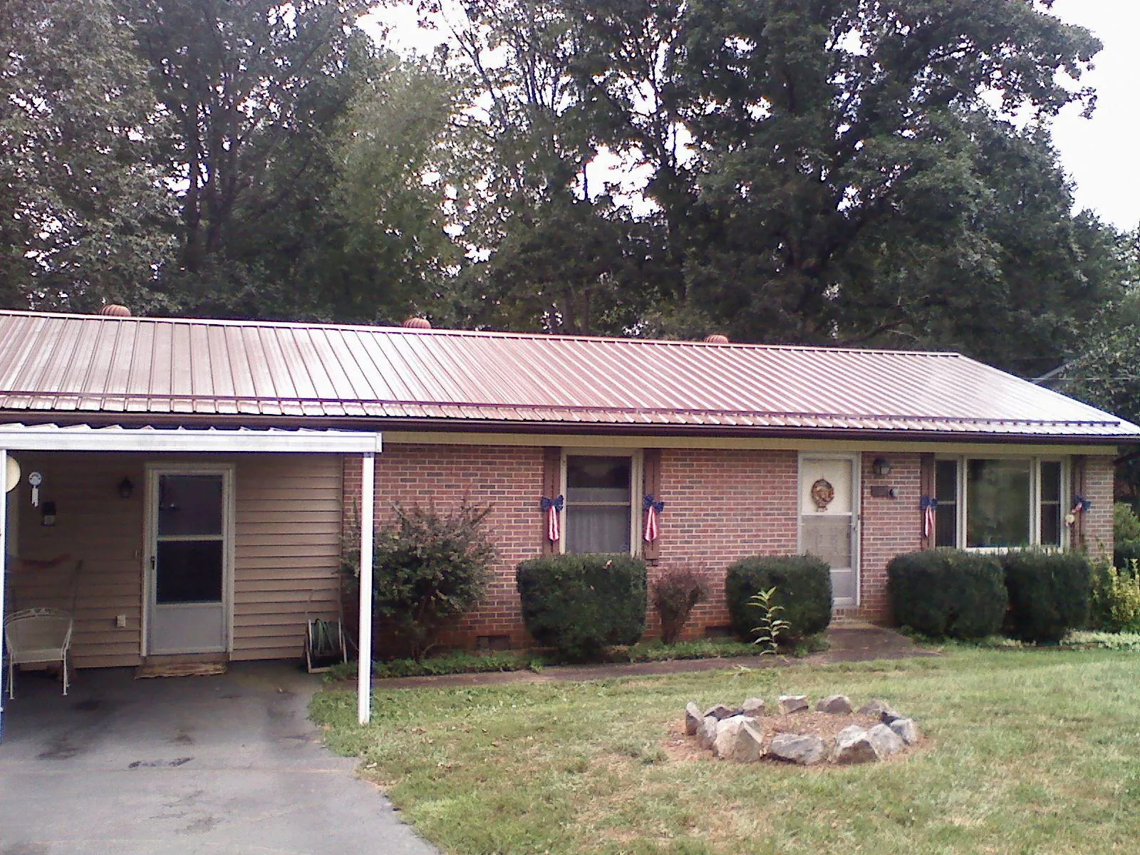 Bronze metal roof and carport on a brick ranch home — Roof Repair work by our crew in Haydenville